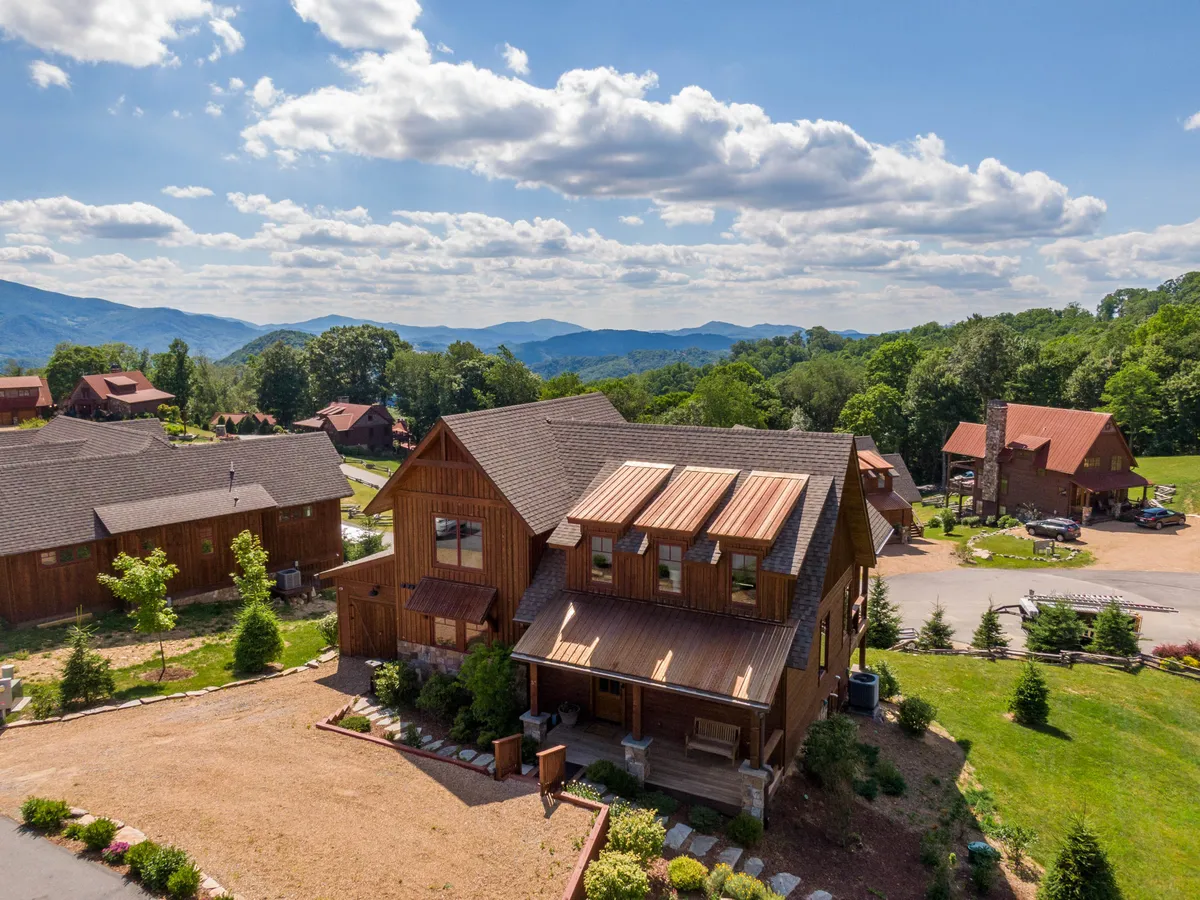 This exterior shot highlights the wooden façade of the lodge, surrounded by greenery, with expansive mountain vistas and a cloud-filled sky. The house’s porch and pathways suggest access to walking trails and opportunities for relaxation with a pet nearby. The tranquil, welcoming mood reinforces the idea of enjoying nature together with your dog.