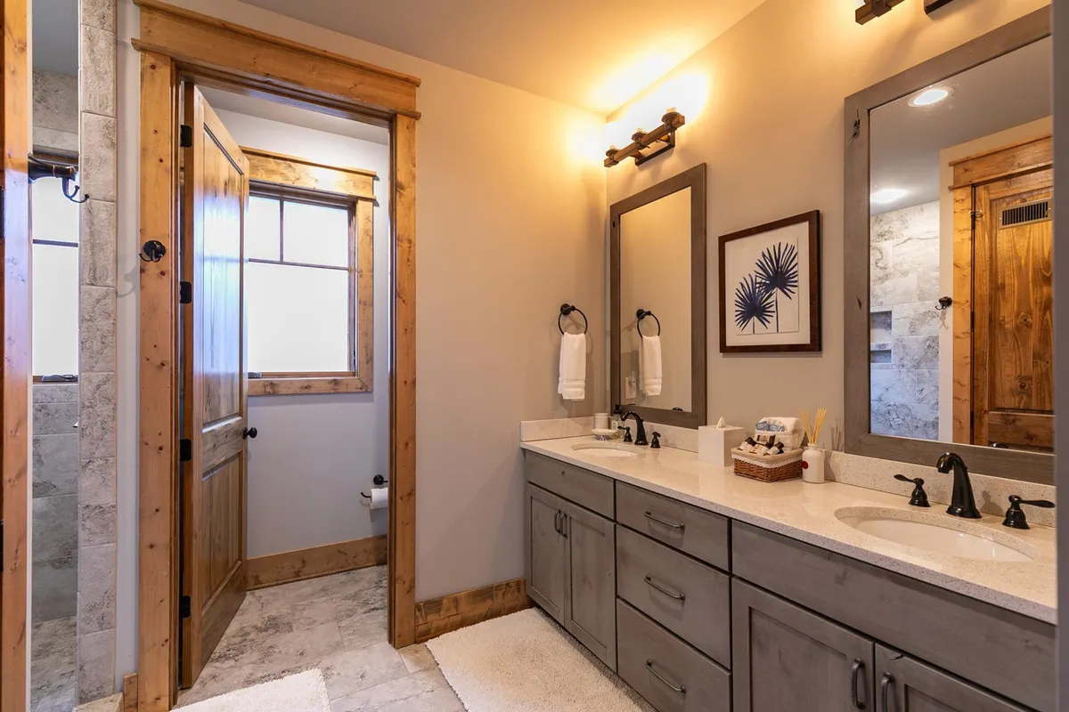 A spa-inspired bathroom with a double sink vanity, wooden accents, mirrors, and towel racks. The space feels organized, calming, and luxurious—perfect for rejuvenation after a long day.