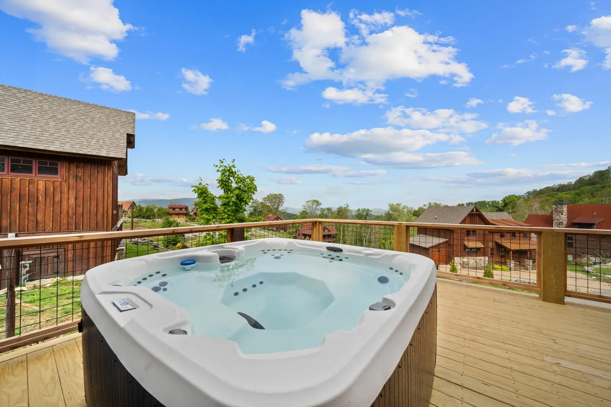 This image highlights a private hot tub on a wooden deck with sweeping views of the surrounding landscape. The setting is tranquil, perfect for relaxing with a drink in hand while watching the sunset or stargazing at night. The hot tub's position on the deck emphasizes both comfort and the immersive natural experience.
